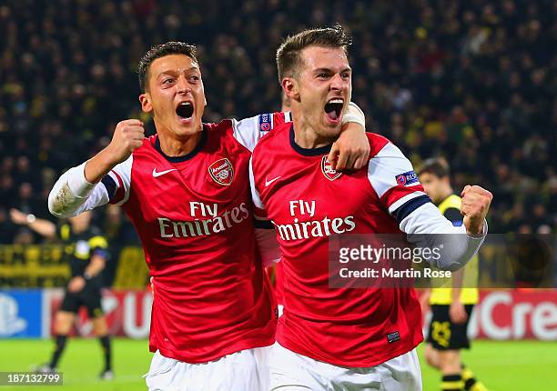 Aaron Ramsey of Arsenal celebrates scoring their first goal with Mesut Oezil of Arsenal during the UEFA Champions League Group F match between...