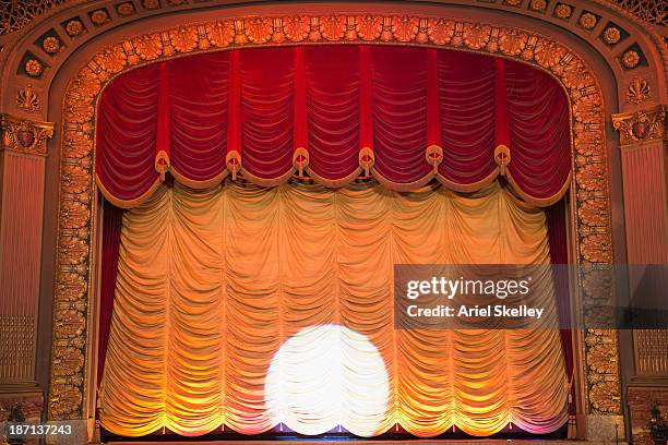 spotlight on curtain in ornate movie theater - rideau de scène photos et images de collection