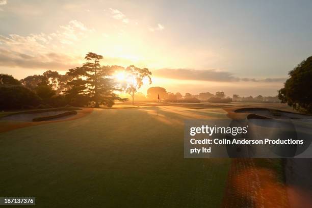 sun rising over golf course - golfplatz stock-fotos und bilder