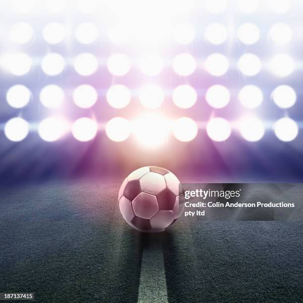 soccer ball rolling towards stadium lights - stadium lights stock-fotos und bilder