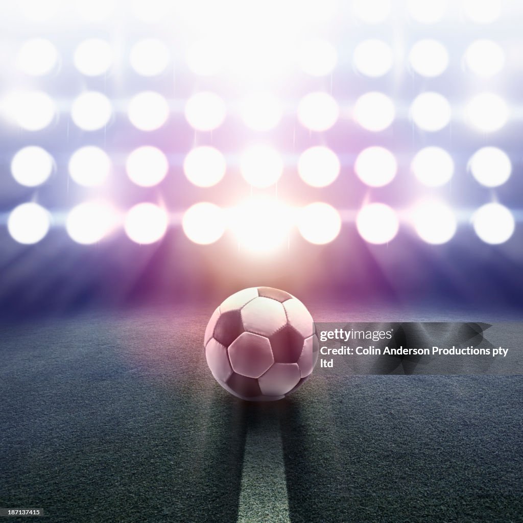 Soccer ball rolling towards stadium lights