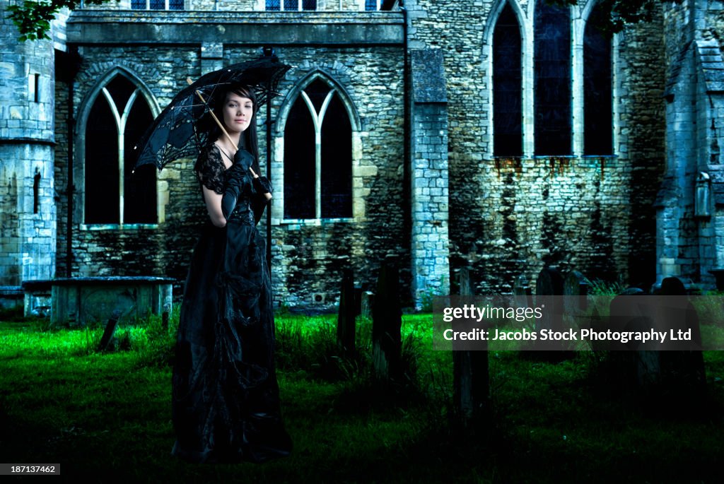 Pacific Islander woman in black gown in graveyard