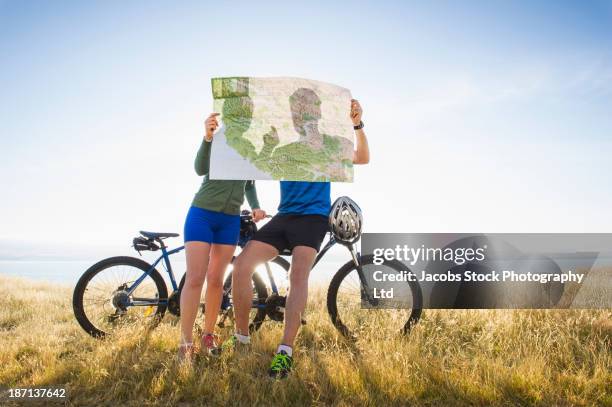 caucasian couple reading map in rural landscape - travel guidance stock pictures, royalty-free photos & images