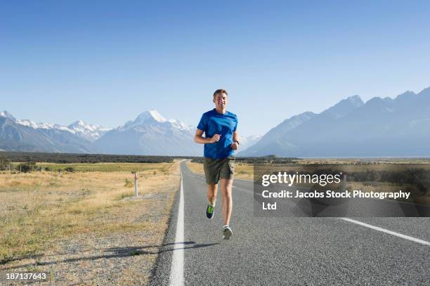 caucasian man running on rural road - fotografia de três quartos imagens e fotografias de stock