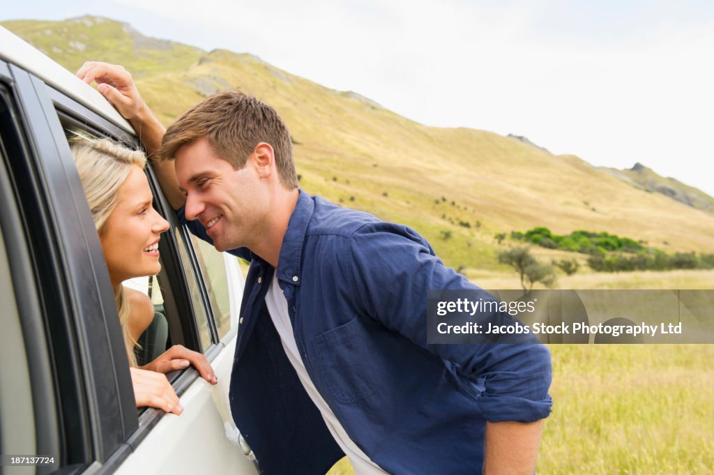 Caucasian couple talking in car