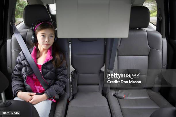 mixed race girl watching television in backseat - kid car seat stock pictures, royalty-free photos & images