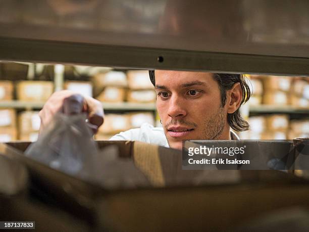 mixed race worker examining bin in textile factory - industrial storage bins stock pictures, royalty-free photos & images