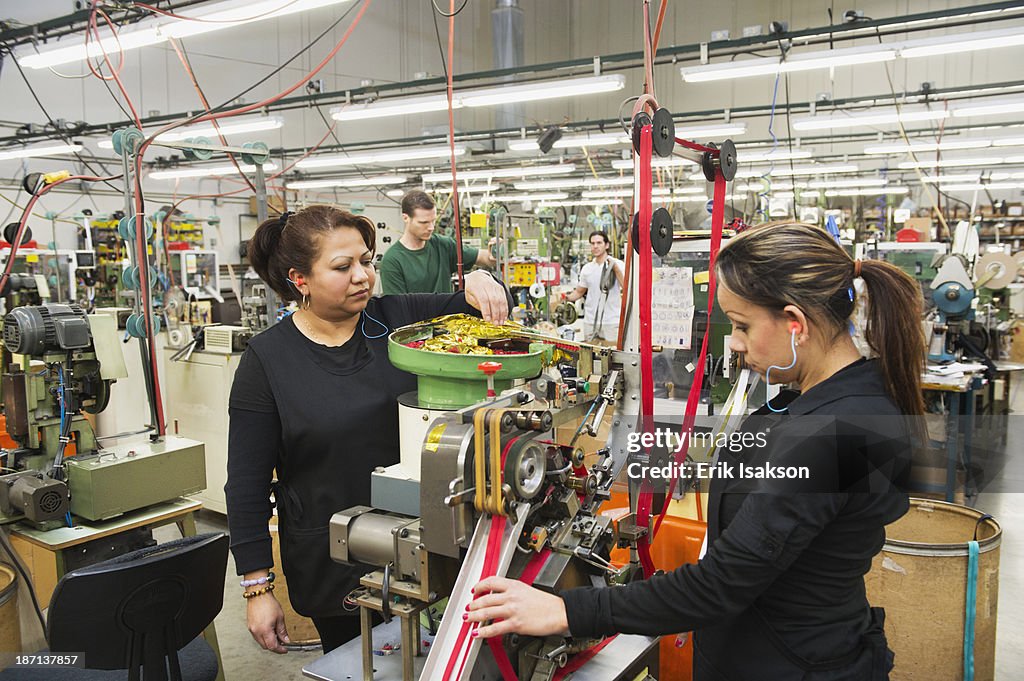 Workers operating machinery in textile factory