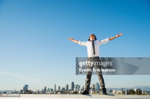 Mixed race businessman standing on urban rooftop Mixed race businessman standing on urban rooftop