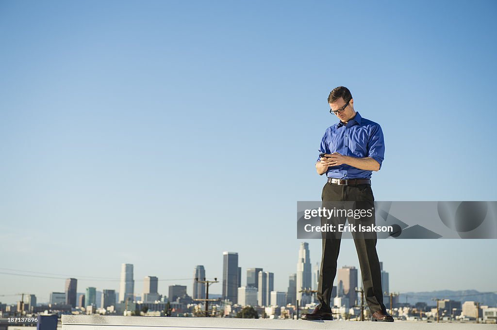 Caucasian businessman standing on urban rooftop