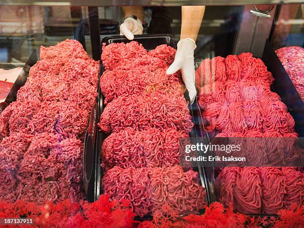 hispanic butcher at meat counter of grocery store - ground beef stock pictures, royalty-free photos & images