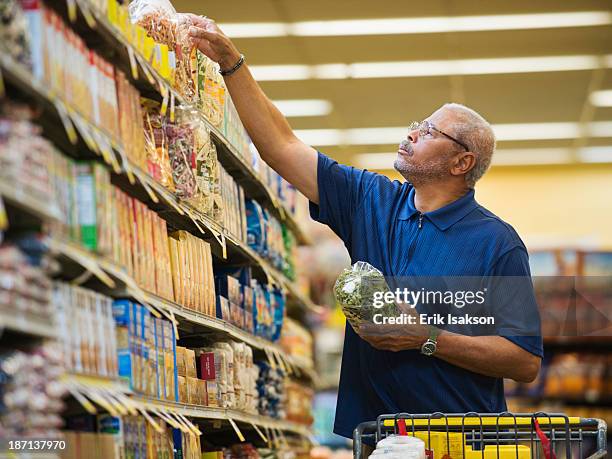 african american man shopping in grocery store - seniors shopping stock pictures, royalty-free photos & images