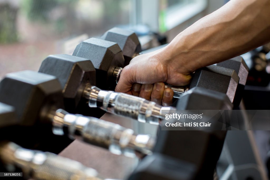 Pacific Islander man lifting weights in gym