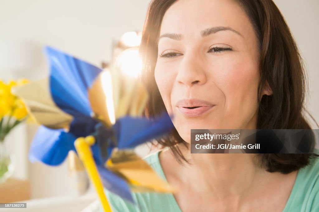 Caucasian woman blowing pinwheel