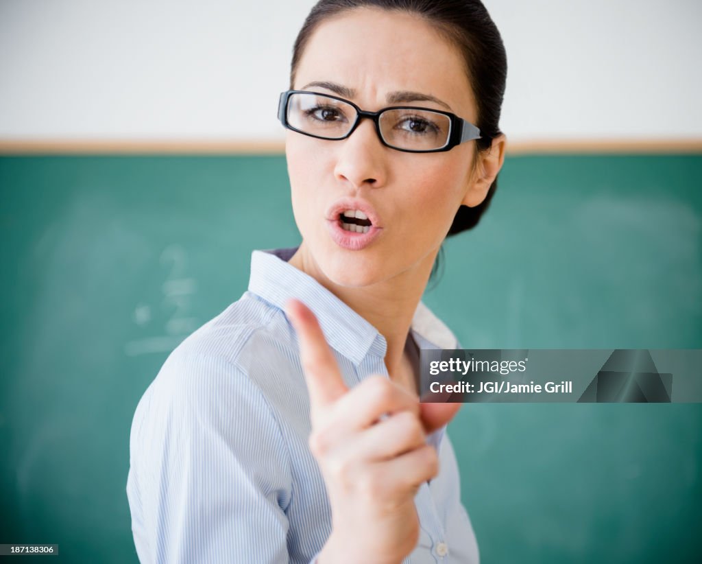 Caucasian teacher scolding in classroom