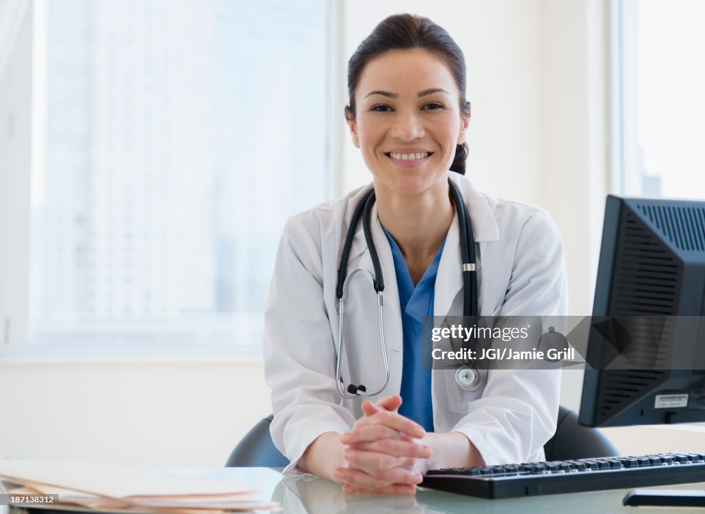Caucasian doctor smiling at desk