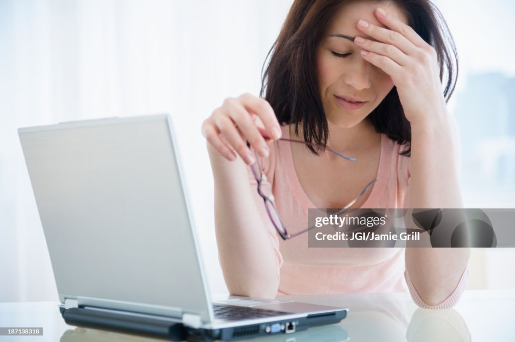 Frustrated Caucasian woman using laptop