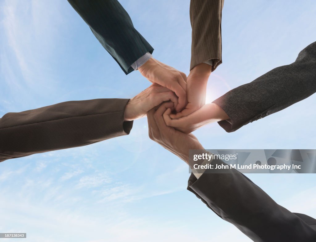 Business people holding hands in circle