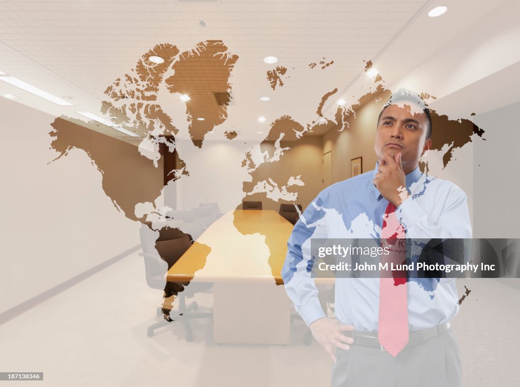 Mixed race businessman examining world map