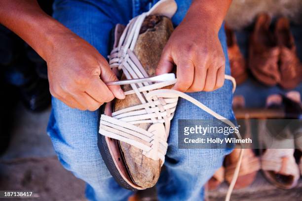 close up of craftsman weaving sandal in shop - san cristobal - fotografias e filmes do acervo