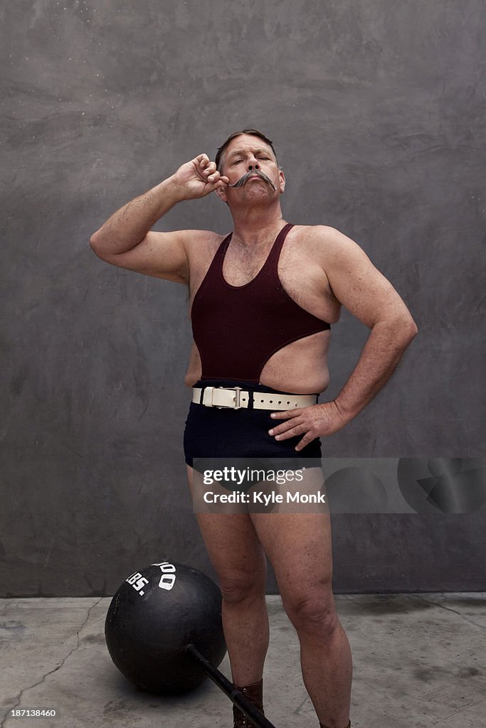 Caucasian weight lifter twirling his mustache