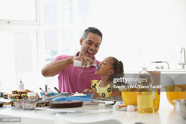 mixed race father and daughter eating whip cream - cream mouth stock pictures, royalty-free photos & images