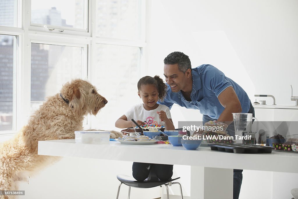 Mixed race father and daughter baking together