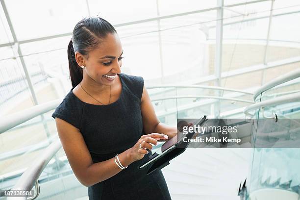 indian businesswoman using digital tablet - woman looking down smiling stock pictures, royalty-free photos & images