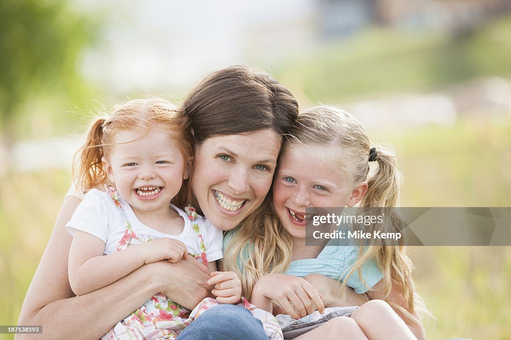 Caucasian mother and daughters smiling outdoors