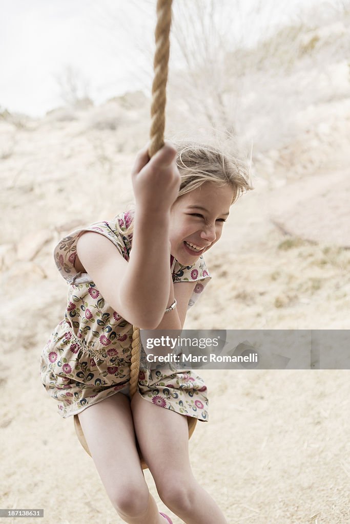 Caucasian girl on rope swing