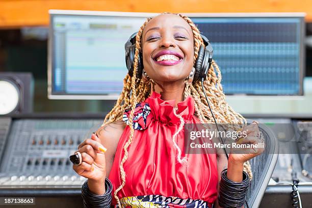 african american singer listening to track in studio - music producer stock pictures, royalty-free photos & images