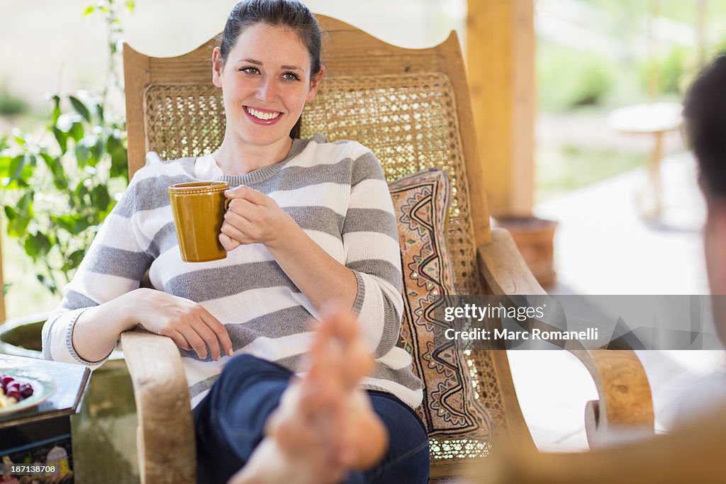 Caucasian woman having cup of coffee on patio