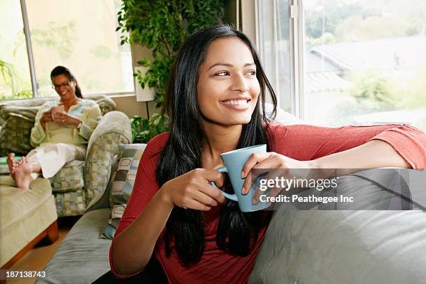 indian woman having cup of coffee on sofa - arab coffee stock pictures, royalty-free photos & images
