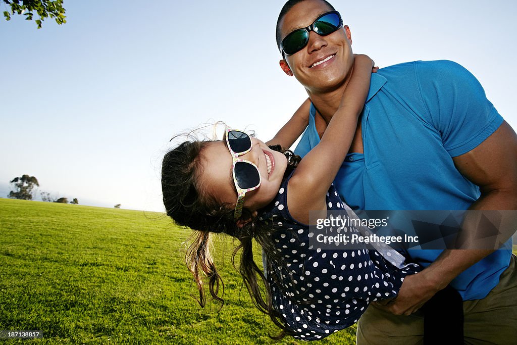 Father and daughter playing in field