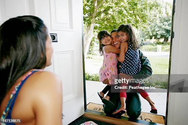 girls hugging soldier father at door - open day 5 stockfoto's en -beelden