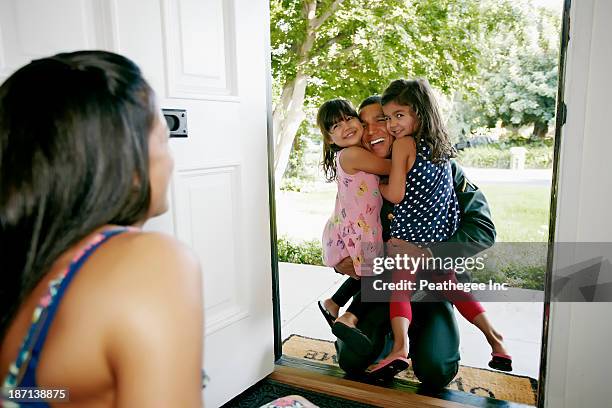 girls hugging soldier father at door - open day 4 stock pictures, royalty-free photos & images