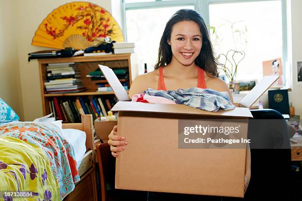 mixed race college student unpacking in dorm - dorm room stock pictures, royalty-free photos & images