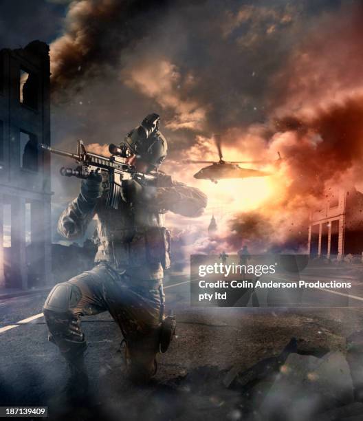 caucasian soldier with gun in combat zone - hélicoptère ville photos et images de collection