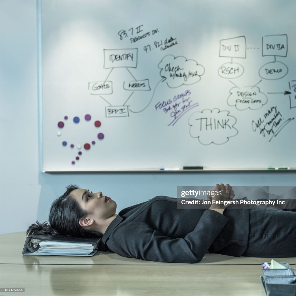 Filipino businesswoman laying on desk