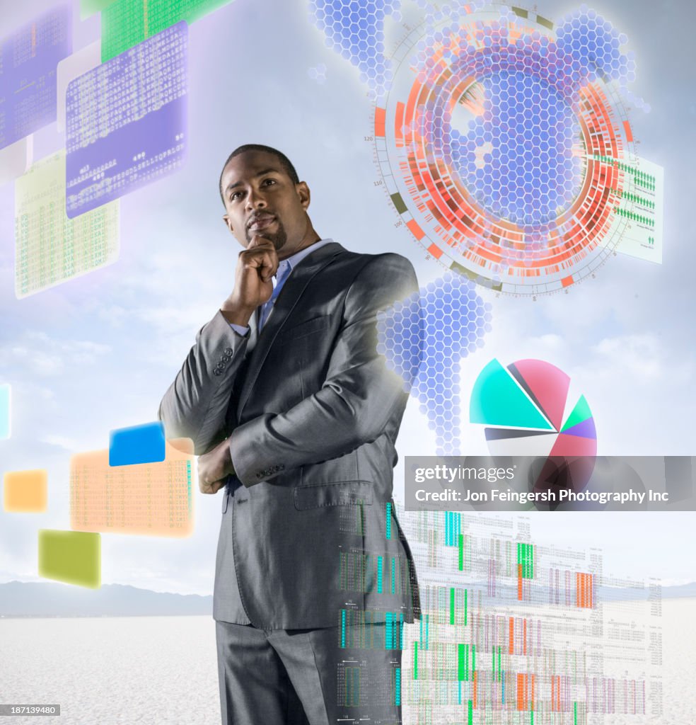 African American businessman examining illuminated holograms