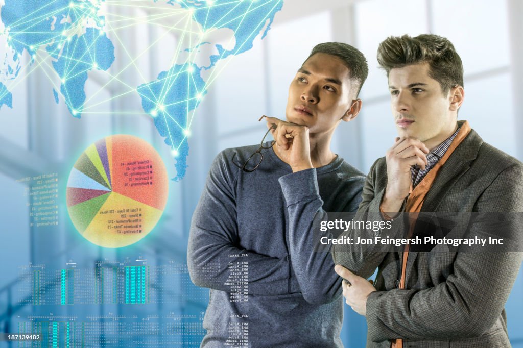 Men examining illuminated holograms