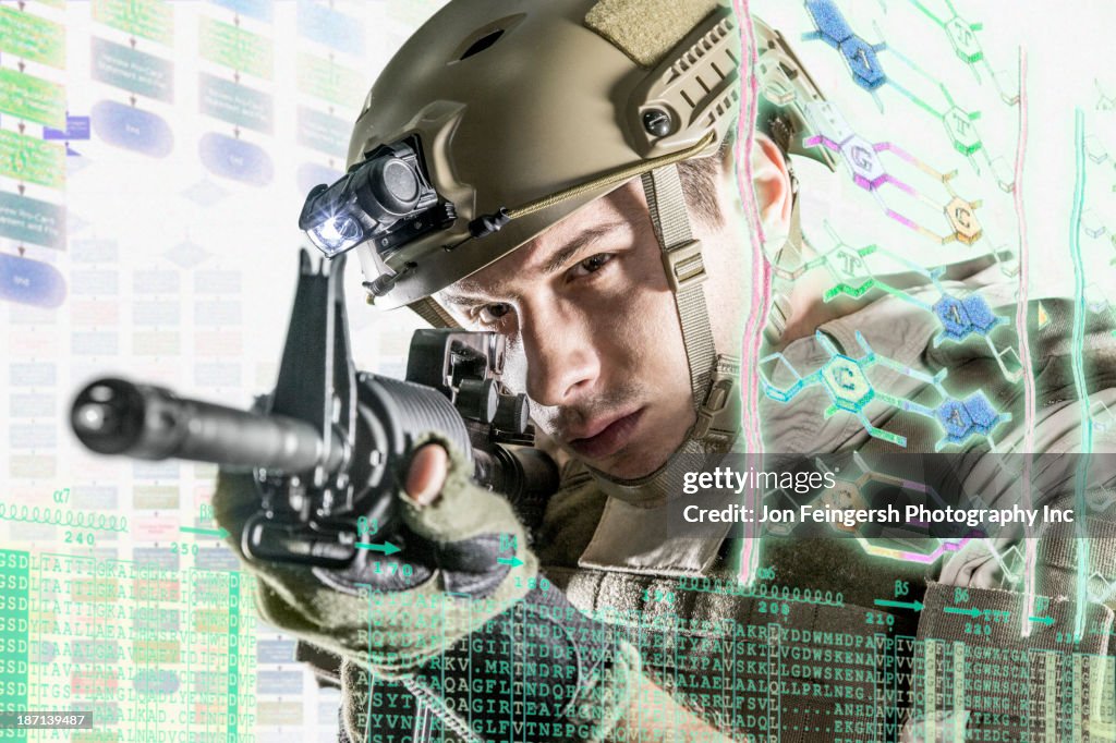 Caucasian soldier pointing gun at illuminated holograms