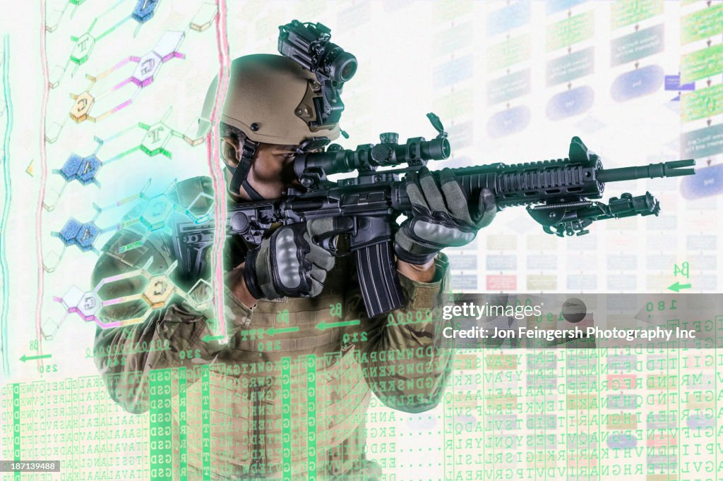 Caucasian soldier pointing gun at illuminated holograms