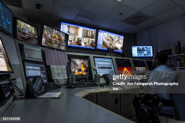 african american security officer working in control room - control room monitors stockfoto's en -beelden