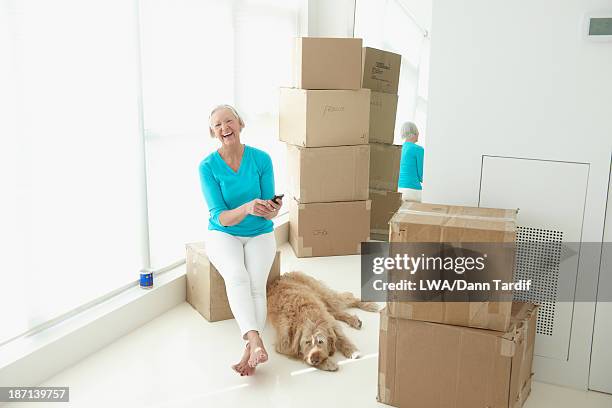 caucasian woman laughing in new home - elderly receiving paperwork stock pictures, royalty-free photos & images