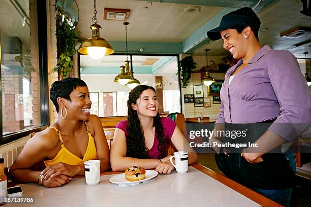 waitress talking to customers in restaurant - waitress booth stock pictures, royalty-free photos & images