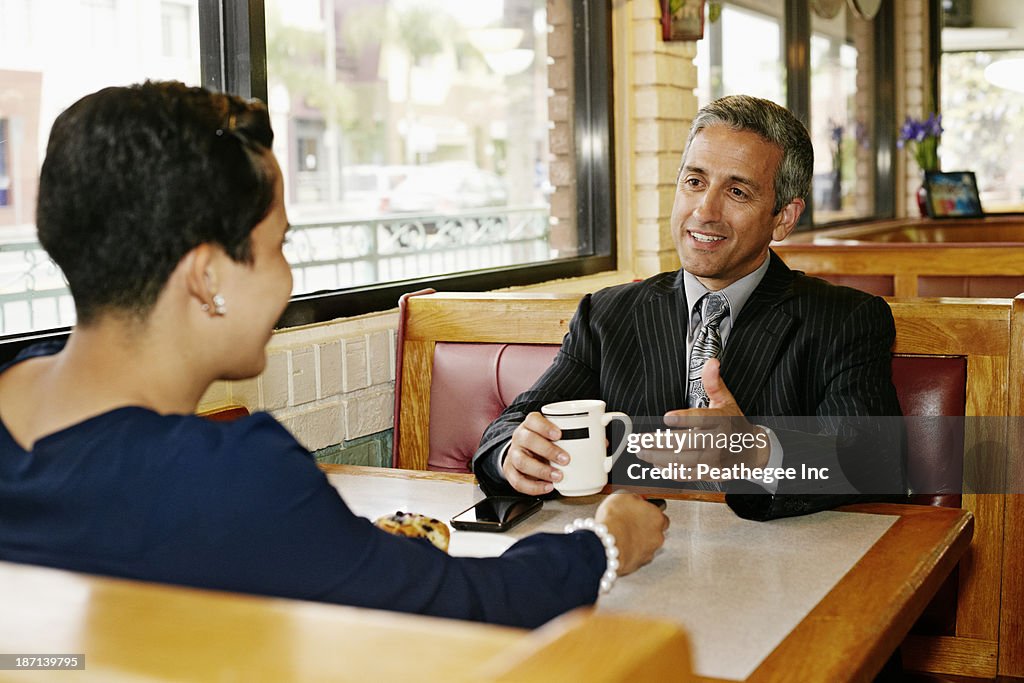 Hispanic business people talking in restaurant