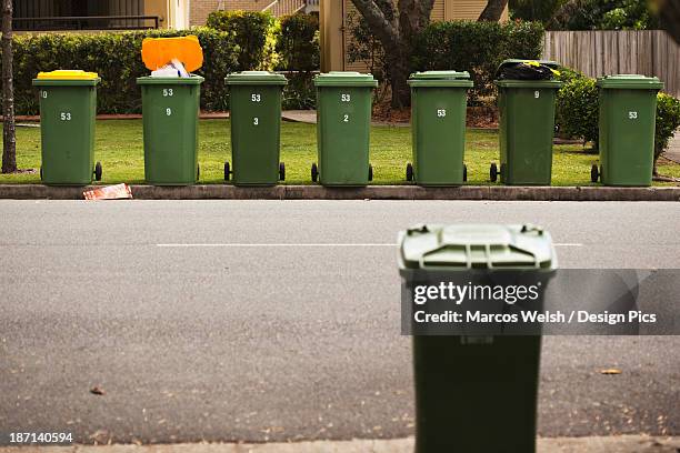 rubbish bins on a curb in a residential area - wastepaper bin stock pictures, royalty-free photos & images