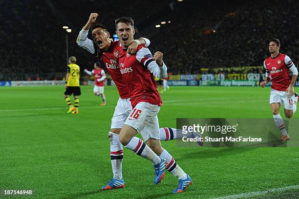 Aaron Ramsey of Arsenal celebrates with team-mate Mesut Oezil after scoring the opening goal during the UEFA Champions League Group F match between...