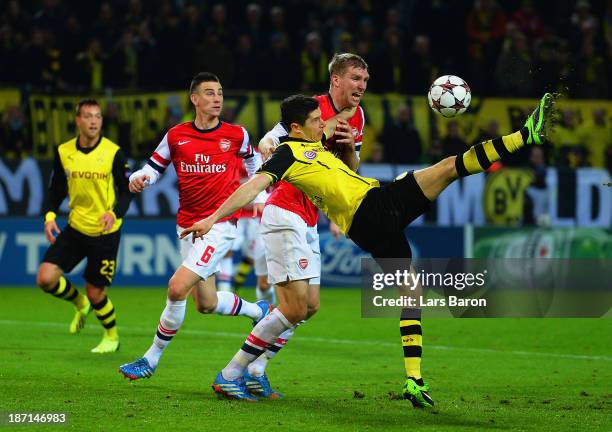 Per Mertesacker of Arsenal challenges Robert Lewandowski of Borussia Dortmund during the UEFA Champions League Group F match between Borussia...